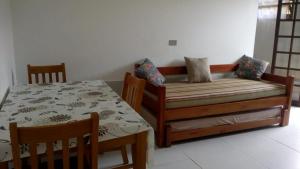 - une chambre avec un lit, une table et des chaises dans l'établissement Chalés Flamboyant, à Caraguatatuba