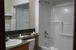 a bathroom with a sink and a toilet and a shower at Slumber Lodge in Penticton