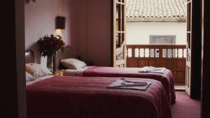 a hotel room with two beds and a window at Casona Santa Catalina Cusco in Cusco