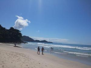 a group of people walking on the beach at Kitnet in Ubatuba