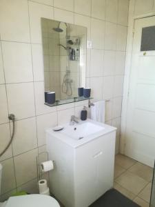 a bathroom with a white sink and a mirror at The Tram 18 Space in Lisbon