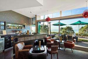 un restaurante con un bar con mesas y sillas en Millennium Hotel New Plymouth, Waterfront, en New Plymouth