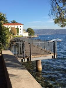 a dock on a body of water with a building at B&B Agora' in Gardone Riviera