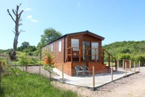 a tiny house with a deck in a field at Mountain View in Taynuilt