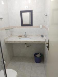 ein Bad mit einem Waschbecken und einem Spiegel in der Unterkunft Ap. Completo Enseada in Guarujá
