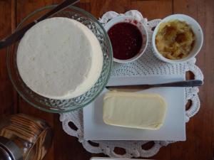 einen Tisch mit einem Teller Essen und etwas Butter in der Unterkunft Pousada Verde Villas in Brumadinho