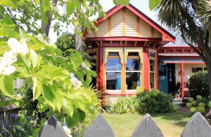 a small house with a fence in front of it at Chester St Backpackers in Christchurch