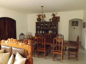 a dining room with a wooden table and chairs at Sitio do Tonetti in Mairiporã +6 photos