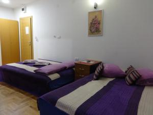 - 2 lits dans une chambre de couleur violette et blanche dans l'établissement Villa Stanisic, à Sarajevo