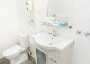 ein weißes Bad mit einem WC und einem Waschbecken in der Unterkunft Shoreline Hotel in Hobart