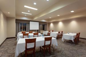 a conference room with tables and chairs and a whiteboard at Wingate by Wyndham Moses Lake in Moses Lake
