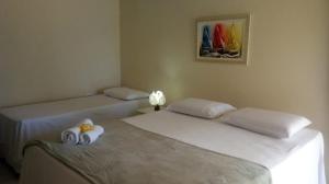 duas camas individuais num quarto com duas toalhas em Pousada Canto do Boldró em Fernando de Noronha