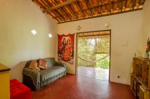 sala de estar con sofá y puerta corredera de cristal en Casa da Pipoca, en Morro de São Paulo