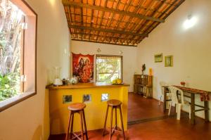 a kitchen with a counter and stools in a room at Casa da Pipoca in Morro de São Paulo +8 photos