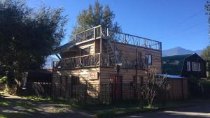 ein Holzhaus mit Balkon darüber in der Unterkunft Willhouse Hostel in Pucón
