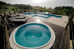 eine große blaue Badewanne auf einer Terrasse neben einem Pool in der Unterkunft Cabañas Valle de los Ciervos in Tandil