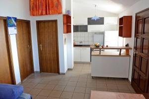 uma cozinha com armários brancos e uma bancada em Private island Šćitna - HOUSE LUEL em Murter