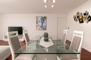 una mesa de comedor de cristal con sillas y un cactus. en Angel´s Paradise Luxury and Sophistication, en Funchal