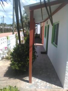une terrasse couverte à l'avant d'une maison avec un poteau rouge dans l'établissement La Coronilla ,Casa de Campo, à La Coronilla