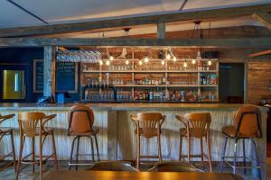 a bar with wooden stools in a restaurant at Auberge de Jeunesse Le Camp De Base in LʼAnse-Saint-Jean