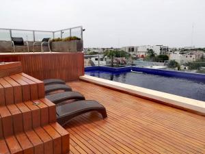 una terraza con sillas y una piscina en un edificio en Iris Studios & Apartments, en Playa del Carmen 5 fotos más