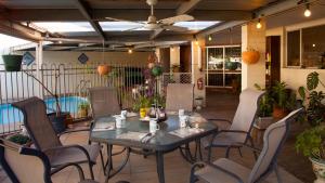 un patio con mesa, sillas y piscina en Kathys Place Bed and Breakfast, en Alice Springs