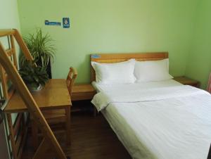 a bedroom with a bed and a desk and a bed and a table at LETE Hostel in Xining