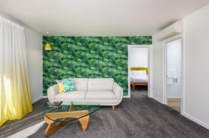 a living room with a couch and a green wall at Adelphi Motel in Christchurch