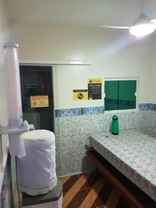 a bathroom with a toilet and a table in a room at Pousada Pouso Feliz in Fortaleza