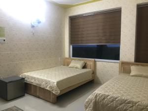 a bedroom with two beds and a window at QUEEN HOTEL Khách sạn QUEEN in Ngọc Tĩnh