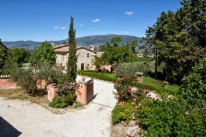 un giardino fiorito e una casa sullo sfondo di La Tenuta Dei Ricordi a Castel Ritaldi