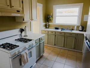 uma cozinha com um fogão branco e um lavatório em Spacious, Sunny House in Berkeley/Oakland Rockridge em Oakland