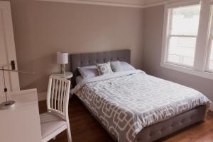 um quarto com uma cama com uma cadeira e uma janela em Spacious, Sunny House in Berkeley/Oakland Rockridge em Oakland
