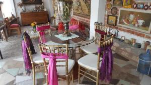 Santa Rosa de Jáuregui的住宿－La Casona Azul Bed n Breakfast，一间用餐室,配有一张桌子和椅子,并拥有紫色的弓