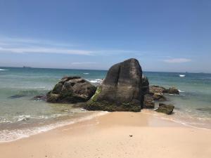 a large rock in the water on a beach at QUEEN HOTEL Khách sạn QUEEN in Ngọc Tĩnh