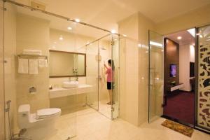 a woman taking a picture of a bathroom with a shower at Hùng Mạnh Plaza Hotel in Hương Tân Lạc