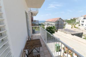 einen Balkon mit einer Bank und Meerblick in der Unterkunft Apartments Marija Jug in Primošten