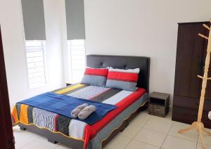 una camera da letto con un letto e due asciugamani di HZ Homestay @Ascotte Boulevard a Semenyih