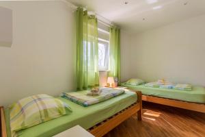 two beds in a room with green curtains at Casa Kujici in Krnica +35 photos