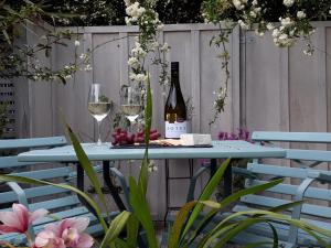 Mapua Studio Quality Accommodation في Mapua: طاولة زرقاء مع كؤوس النبيذ وزجاجات النبيذ