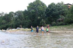 een groep mensen die in het water lopen bij Cabañas Ecoturisticas Y Club Gaira Tayrona in Santa Marta