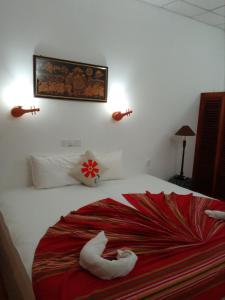 ein Schlafzimmer mit einem Bett mit Handtuchtieren darauf in der Unterkunft Benta villa in Bentota