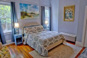 ein Schlafzimmer mit einem Bett und zwei Fenstern in der Unterkunft Beautiful 6 Bed, 5 Bath Historic Savannah Home in Savannah