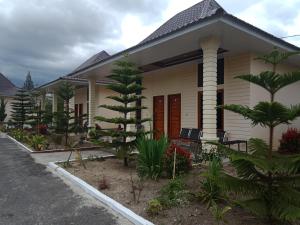 ein Haus mit einem Baum davor in der Unterkunft Noah Hotel Silangit in Siborongborong