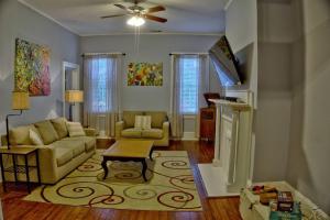 a living room with a couch and a tv at Beautiful 6 Bed, 5 Bath Historic Savannah Home in Savannah