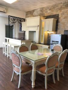 a dining room table with chairs and a kitchen at Bideco Hotel in Thu Dau Mot