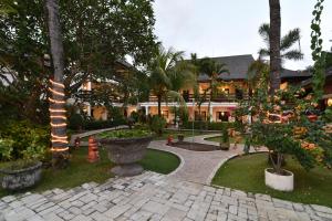 a courtyard with trees and a building with a building at Palm Garden Hotel in Sanur