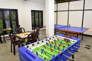 a ping pong table in a room with tables and chairs at Hotel Treetop in Thekkady