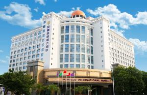 a large white building with aidium international hotel at Shenzhen Dayhello international Hotel (Baoan) in Bao'an