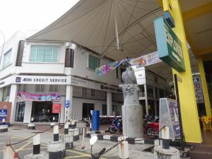 a building with a statue in the middle of a street at Famosa 2 Stay in Malacca